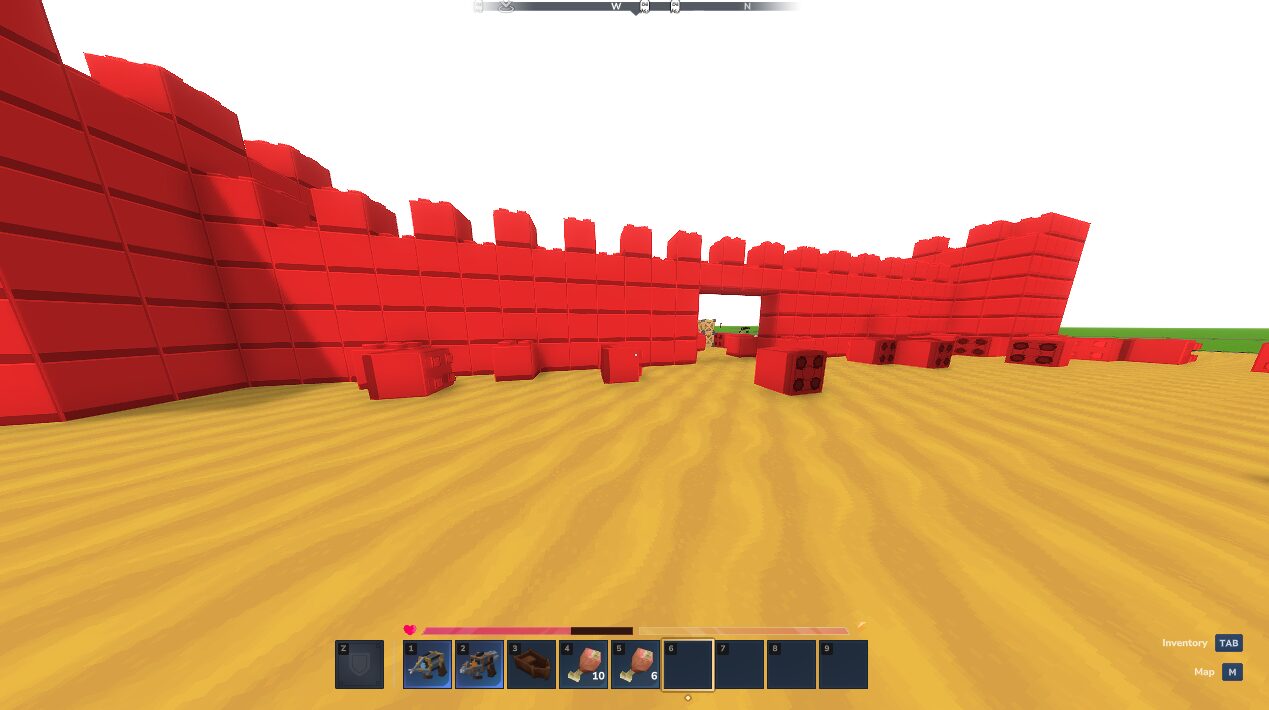 A long red brick wall with a gap in it and loose red blocks scattered on the sand in front.